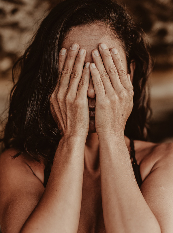 Haut_und_Stress_RAU-Cosmetics (1) Frau mit Händen vor dem Gesicht, symbolisiert Stress und Hautprobleme, in Zusammenhang mit den Auswirkungen von Stress auf die Hautgesundheit.
